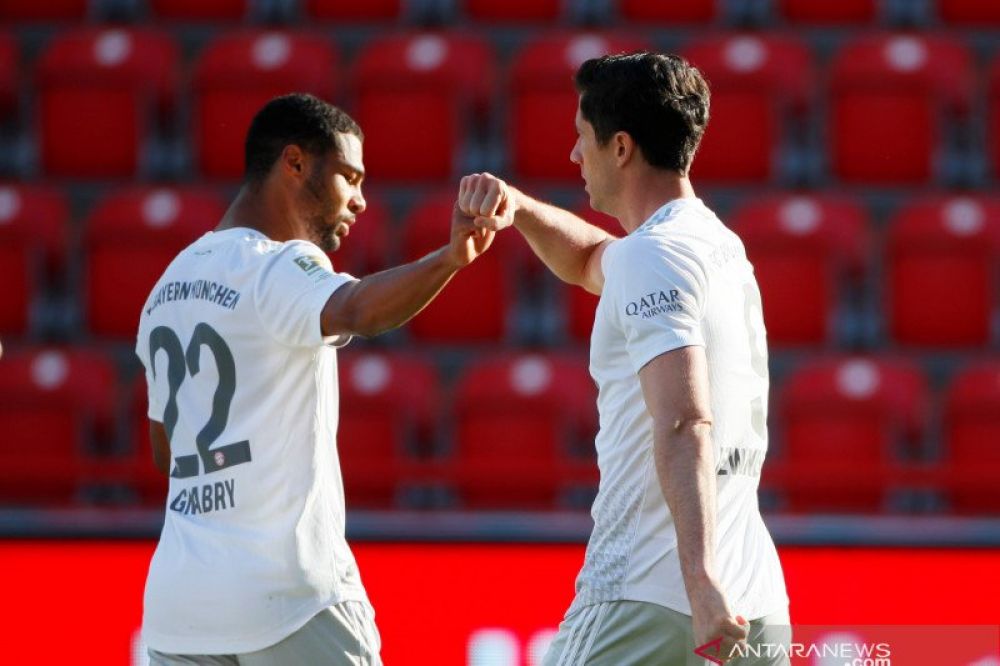 Penyerang Bayern Munich Robert Lewandowski (kanan) dan Serge Gnabry (kiri) merayakan gol yang tercipta dalam pertandingan Liga Jerman melawan Union Berlin yang dimainkan di di Stadion An der Alten Foersterei, Berlin, Minggu (17/5/2020). (ANTARA/AFP/HANNIB