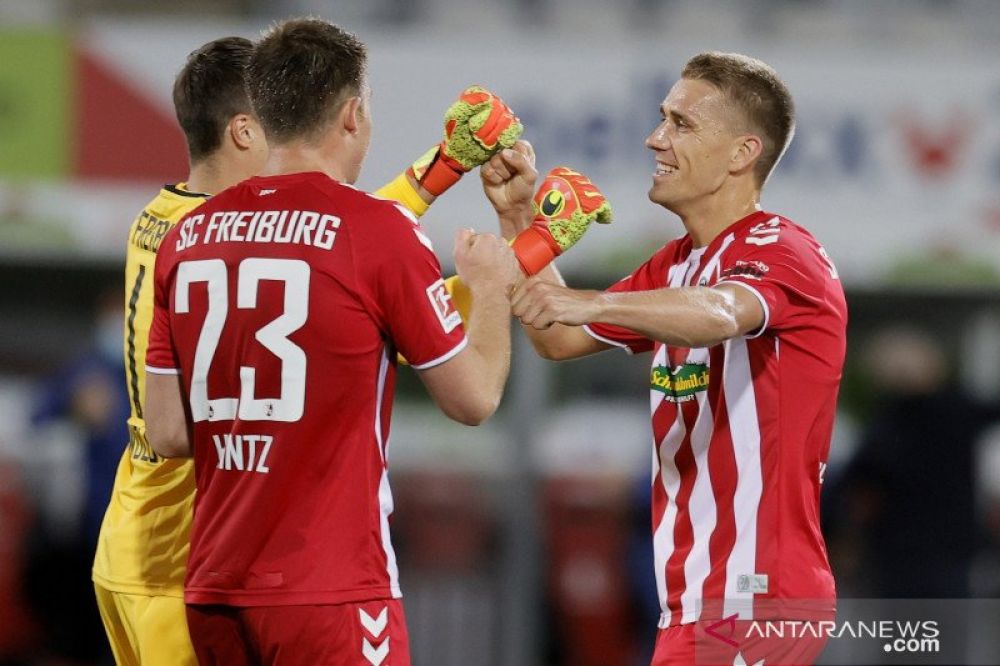 Penyerang Freiburg Nils Petersen (kanan) merayakan kemenangan bersama bek Dominique Heintz (tengah) dan kiper Alexander Schwolow (kiri) setelah pertandingan Liga Jerman melawan Borussia Moenchengladbach, yang dimainkan di Stadion Schwarzwald. Freiburg, Ju