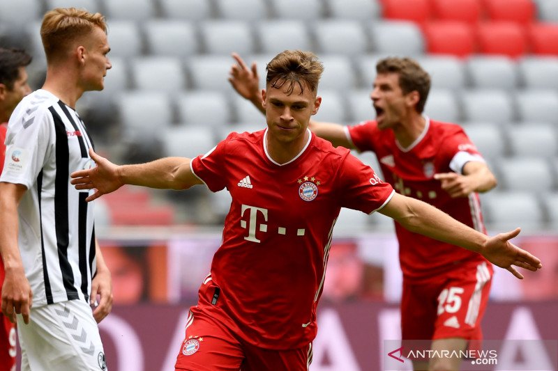 Gelandang Bayern Munich Joshua Kimmich (tengah) merayakan gol yang dicetaknya ke gawang Freiburg dalam pertandingan Liga Jerman yang dimainkan di Allianz Arena, Munich, Sabtu (20/6/2020). (ANTARA/AFP/SVEN HOPPE)

