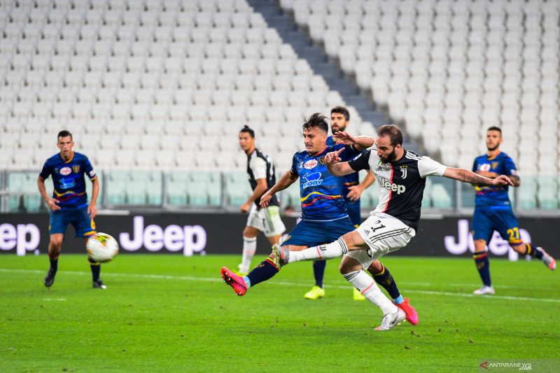 Penyerang Juventus Gonzalo Higuain (kanan) menembakkan bola untuk menjadi gol ketiga dalam pertandingan Liga Italia melawan Lecce yang dimainkan di Stadion Allianz Arena, Turin, Jumat (26/6/2020). (ANTARA/AFP/MIGUEL MEDINA)


