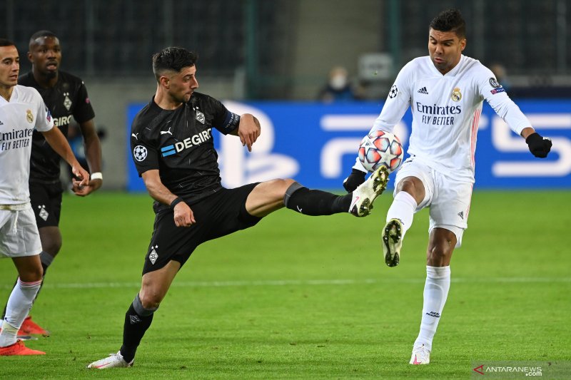 Gelandang Real Madrid Casemiro (kanan) dan gelandang Borussia Moenchengladbach Lars Stindl (kiri) bertarung memperebutkan bola pada pertandingan Grup B Liga Champions yang dimainkan di Borussia Park, Moenchengladbach, Selasa (27/10/2020). (ANTARA/AFP/INA 