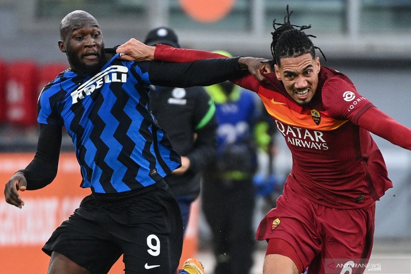 Bek AS Roma Chris Smalling (kanan) berduel dengan penyerang Inter Milan Romelu Lukaku pada pertandingan Liga Italia yang dimainkan di Stadion Olimpico, Roma, Minggu (10/1/2021). (ANTARA/AFP/VINCENZO PINTO)
