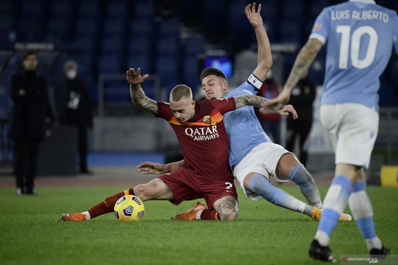 Bek Roma Rick Karsdorp (kiri) dan gelandang Lazio asal Serbia Sergej Milinkovic-Savic berebut bola saat pertandingan Serie A antara Lazio dengan AS Roma di Olympic stadium, Roma, pada Jumat (15/1/2021). (AFP/FILIPPO MONTEFORTE)