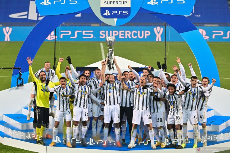 Bek Juventus Giorgio Chiellini (tengah) mengangkat trofi Piala Super Italia bersama rekan-rekan setimnya untuk merayakan keberhasilan mereka mengalahkan Napoli dengan skor 2-0 pada pertandingan yang dimainkan di Stadion Mapei, Sassuolo, Rabu (20/1/2021). 