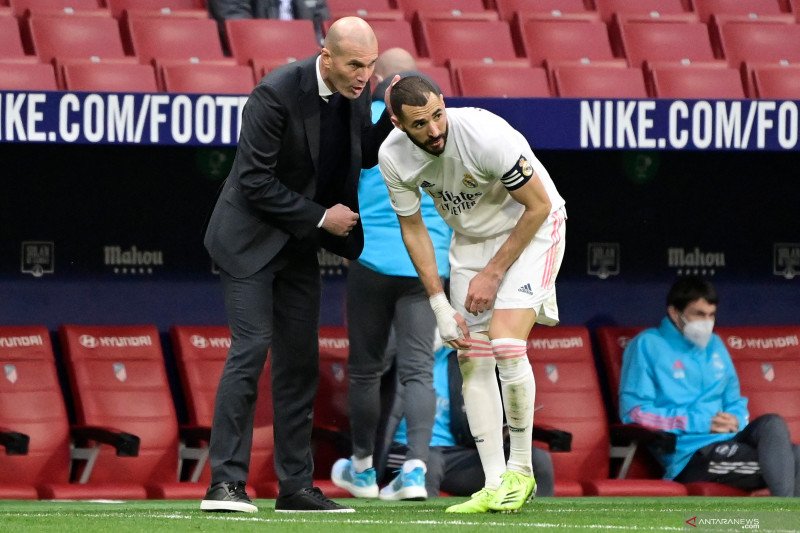 Pelatih Real Madrid, Zinedine Zidane (kiri) sedang berbicara dengan pemainnya Karim Benzema dalam pertandingan Liga Spanyol lawan Atletico Madrid di Wanda Metropolitano, Madrid pada 7 Maret 2021.(AFP/JAVIER SORIANO)

