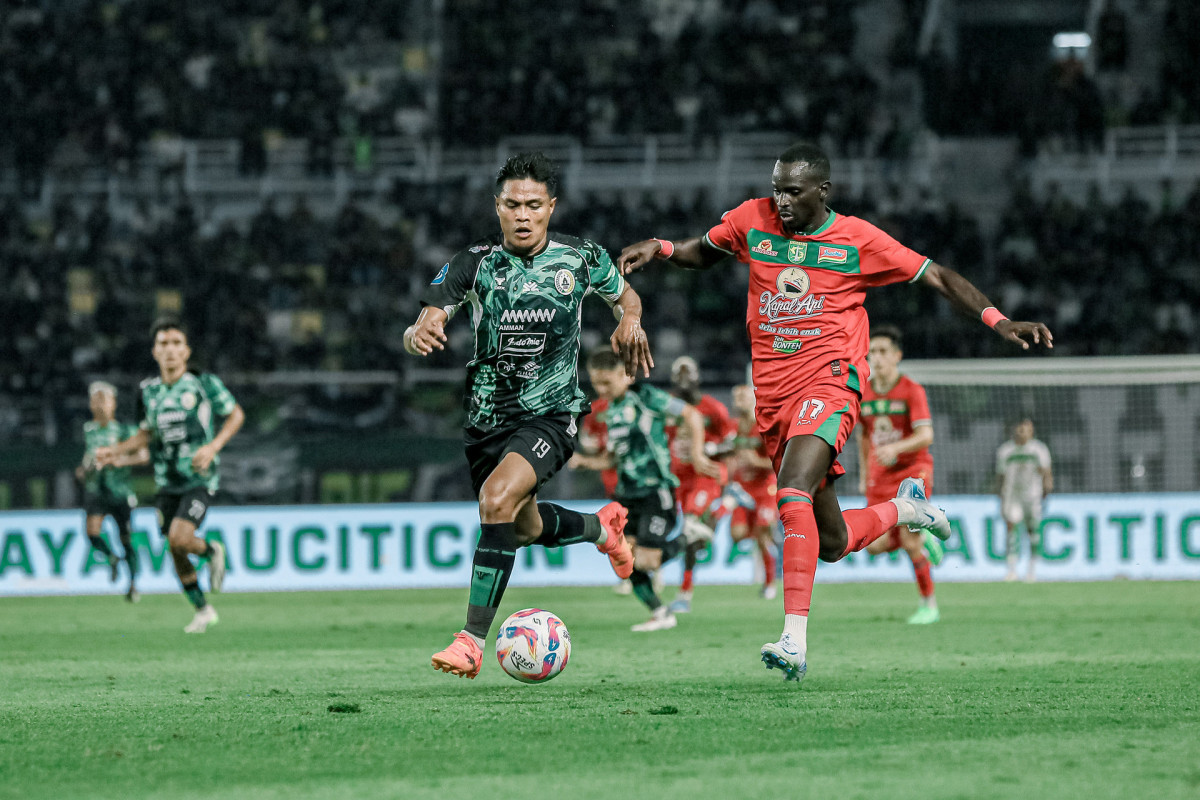 Flavio Silva mempertahankan bola dari rebutan pemain PSS Sleman, Fachrudin Aryanto. (Persebaya)
