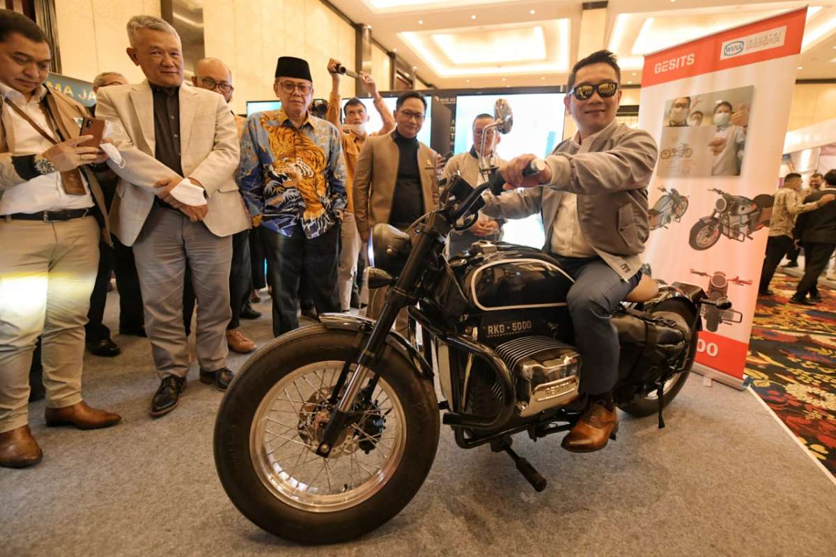 Gubernur Jawa Barat Ridwan Kamil  berpose  dengan prototipe motor listrik rancangannya di arena pameran West Java Investment Summit 2022 di Trans Hotel, Kota Bandung, Rabu (5/10/2022). 