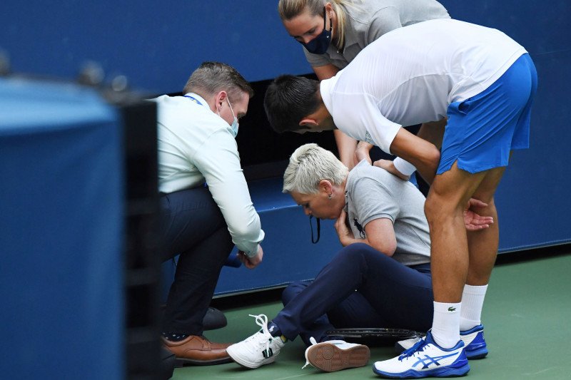 Novak Djokovic dan seorang ofisial turnamen mengecek seorang hakim garis yang terkena bola yang dipukulkan Djokovic saat menghadapi Pablo Carreno Busta dari Spanyol dalam US Open 2020 di USTA Billie Jean King National Tennis Center, New York, pada 6 Septe