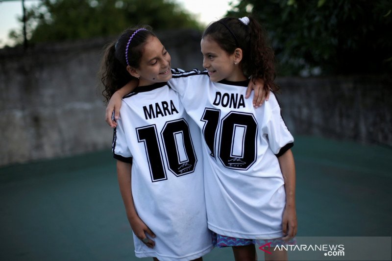 Mara dan Dona, putri kembar Walter Gaston Rotundo, berpose di rumah mereka, di Buenos Aires, Argentina, 27 November 2020. REUTERS / Ueslei Marcelino

