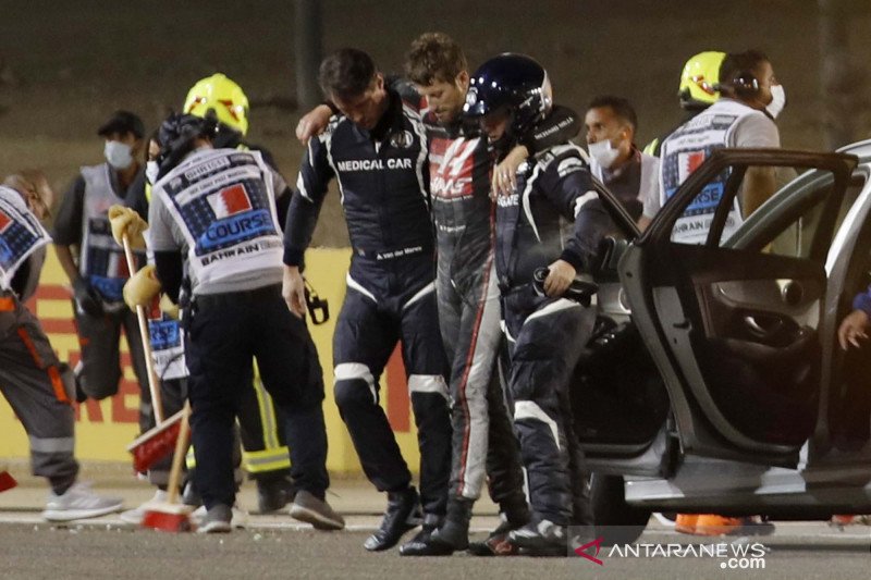 Pembalap Haas Romain Grosjean berjalan menjauh dari lokasi kecelakaan dengan bantuan petugas medis setelah tersingkir dari balap Formula Satu (F1) Grand Prix Bahrain di Sirkuit Internasional Bahrain, Sakhir, Bahrain, Minggu (29/11/2020). ANTARA FOTO/Pool 