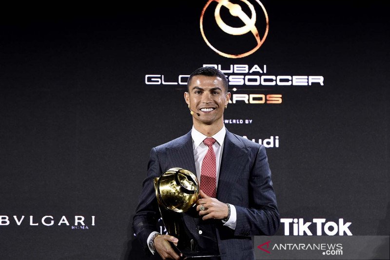 Pemain Juventus Cristiano Ronaldo mengangkat trofi penghargaan Player of the Century Globe Soccer Awards di Armani hotel, Burj Khalifa, Dubai, Uni Emirat Arab (27/12/2020). ANTARA FOTO/LaPresse/Handout via REUTERS/Fabio Ferrari/aww. 

