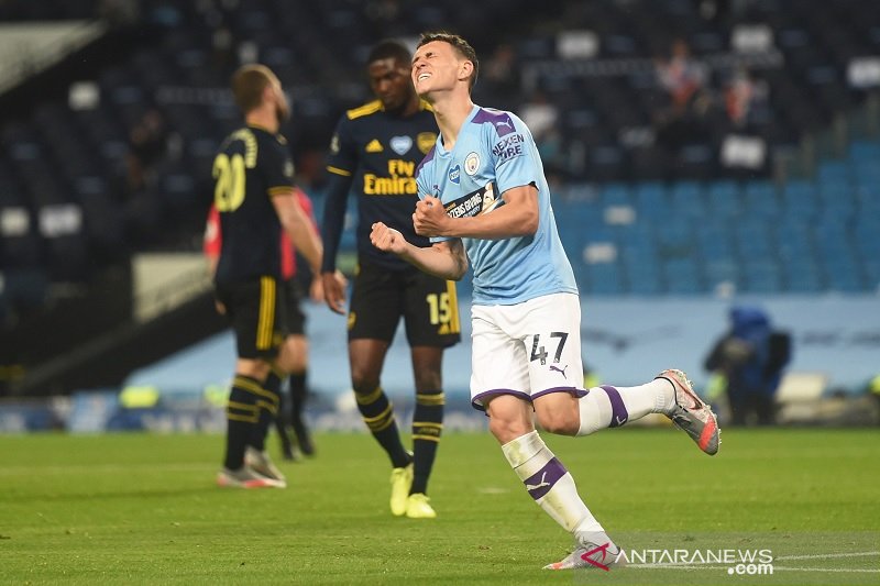 Talenta muda Manchester City Phil Foden melakukan selebrasi usai mencetak gol ketiga timnya ke gawang Arsenal dalam laga lanjutan Liga Inggris yang digelar tanpa penonton karena pandemi COVID-19 di Stadion Etihad, Manchester, Inggris, Rabu (17/6/2020) wak