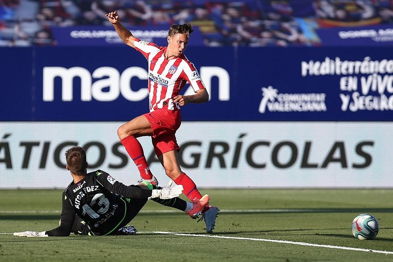 Kiper Levante Aitor Fernandez (kiri) menjegal bola dari penguasaan sayap Atletico Madrid Marcos Llorente dalam laga lanjutan Liga Spanyol tanpa penonton di tengah pandemi COVID-19 di Stadion Camilo Cano, Levante, Spanyol, Selasa (23/6/2020) waktu setempat