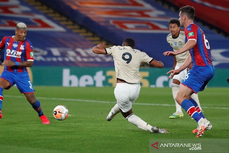 Penyerang Manchester United Anthony Martial (tampak punggung) melakukan tembakan untuk mencetak gol kedua timnya ke gawang Crystal Palace dalam laga lanjutan Liga Inggris tanpa penonton di tengah pandemi COVID-19 di Stadion Selhurst Park, London, Inggris,