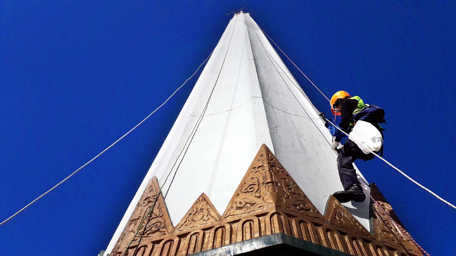 Pekerja mengupas cat sebelum melakukan pengecatan Tugu Pahlawan di Surabaya, Jawa Timur, Kamis (10/9/2020).  FOTO : OM PRASS