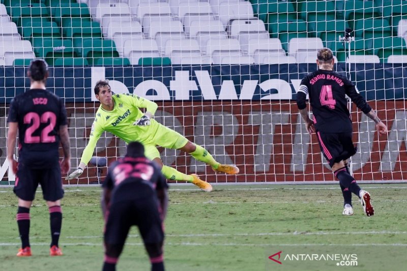 Bek sekaligus kapten Real Madrid, Sergio Ramos (kanan), mengeksekusi tendangan penalti memperdaya kiper Real Betis Joel Robles untuk mencetak gol penentu kemenangan dalam lanjutan Liga Spanyol di Stadion Benito Villamarin, Sevilla, Spanyol, Sabtu (26/9/20