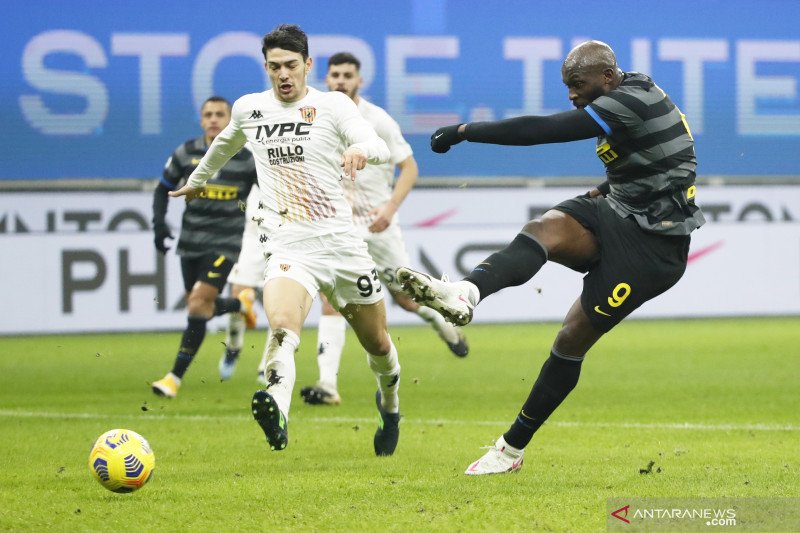 Penyerang Inter Mila Romelu Lukaku (kanan) melepaskan sepakan yang berbuah gol keempat pada pertandingan Liga Italia melawan Benevento yang dimainkan di Stadion Giuseppe Meazza, Milan, Sabtu (30/1/2021). (ANTARA/REUTERS/ALESSANDRO GAROFALO)