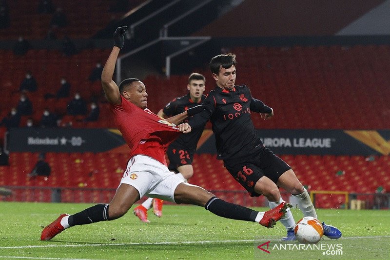 Penyerang Manchester United Anthony Martial (kiri) berduel memperebutkan bola dengan gelandang Real Sociedad Martin Zubimendi dalam pertandingan leg kedua babak 32 besar Liga Europa di Stadion Old Trafford, Manchester, Inggris, Kamis (25/2/2021) waktu set