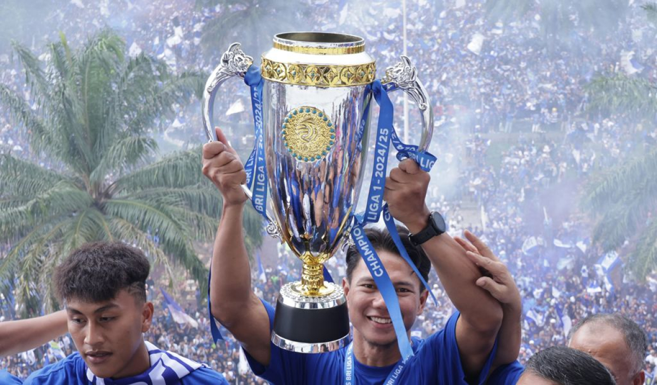 Bek PERSIB, Achmad Jufriyanto mengangkat trofi juara Liga 1 2024/25 di Gedung Sate, Kota Bandung, Minggu, 25 Mei 2025. (PERSIB.co.id/Barly Isham)