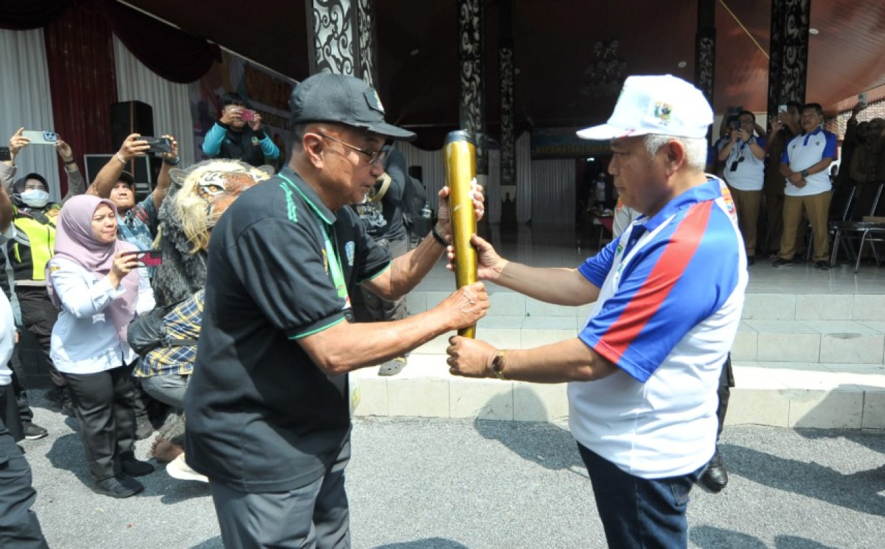 Obor api secara simbolis diterima oleh Bupati Malang, M. Sanusi, dari Ketua PB Porprov Jatim IX 2025, Dedi Suhayadi.
