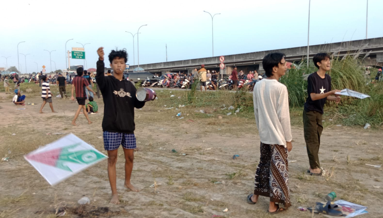 Ratusan orang dari berbagai usia anak-anak, remaja, hingga orang dewasa berbondong-bondong dari berbagai wilayah sekitar memenuhi lahan kosong yang berada di antara akses keluar-masuk tol menuju kawasan Juanda dan Pondok Tjandra.
