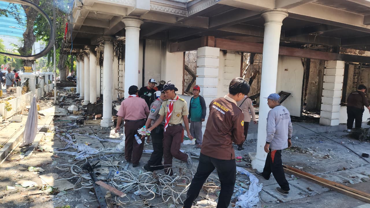 Pramuka Jawa Timur turun tangan melakukan pembersihan Gedung Negara Grahadi yang mengalami kerusakan parah akibat aksi massa yang berlangsung pada Sabtu (30/8/2025) malam.