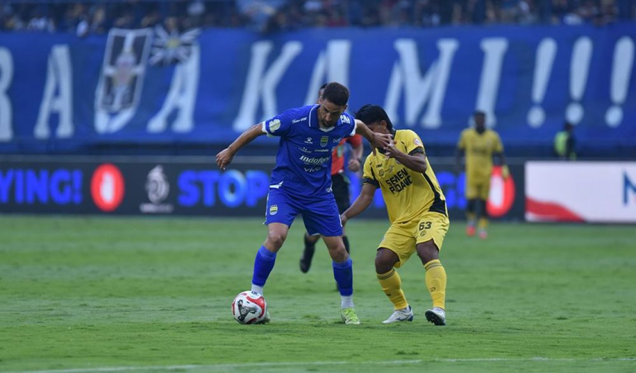 Gelandang PERSIB, Luciano Guaycochea dibayangi pemain Semen Padang pada pertandingan pekan pertama Super League 2025/26 di Stadion Gelora Bandung Lautan Api, Sabtu, 9 Agustus 2025. (PERSIB.co.id/Barly Isham)