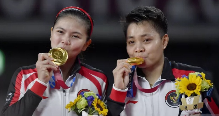 Pebulu tangkis ganda Putri Indonesia Greysia Polii (kiri) dan Apriyani Rahayu mencium medali emas yang mereka raih untuk nomor bulu tangkis ganda putri Olimpiade Tokyo 2020 di Musashino Forest Sport Plaza, Tokyo, Jepang, Senin (2/8/2021). ANT