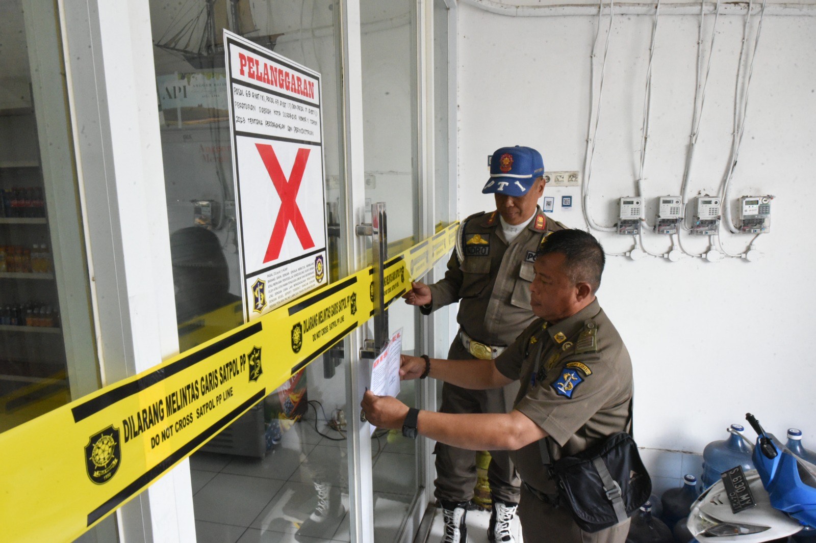 Satpol PPK ota Surabaya, menyegel sebuah toko di perkampungan padat penduduk, kawasan Gubeng Kertajaya I Raya Surabaya