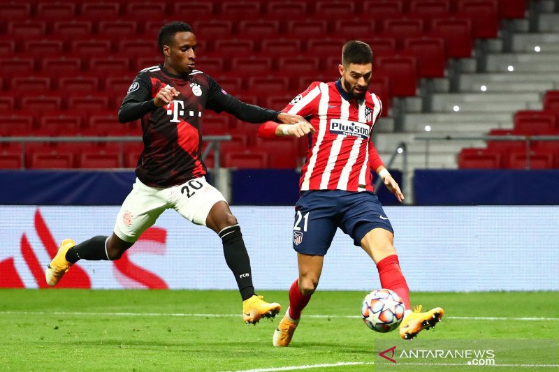 Pemain Bayern Munich Bouna Sarr (kiri) berebut bola dengan Yannick Carrasco (kiri) dari Atletico Madrid dalam laga Grup A Liga Champions, di Madrid, Spanyol, Selasa (1/12/2020). Pertandingan berakhir imbang 1-1. Pelatih Munich menyimpan beberapa pemain ku