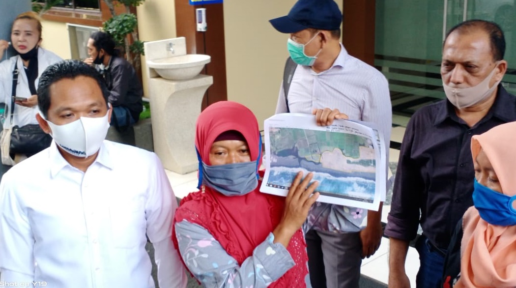 Bupati Lumajang Thoriqul Haq  (kiri) bersama Tijah, istri almarhum Salim Kancil, menunjukan peta lokasi tanah garapan pertanian milik Salim Kancil usai diperiksa Polda Jatim, Kamis (9/7).
