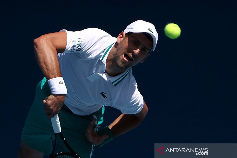 Petenis Serbia Novak Djokovic melakukan service bola ke arah lawannya petenis Amerika Serikat Frances Tiafoe dalam laga babak kedua Turnamen Tenis Australia Terbuka, di  Melbourne Park, Melbourne, Australia, Rabu (10,/2/2021).  Djokovic melaju ke babak ke