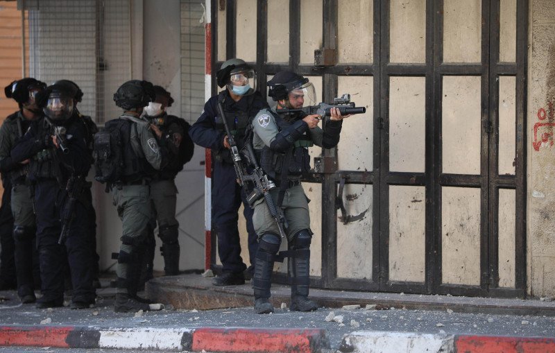 Seorang tentara Israel membidikkan senjatanya ke arah demonstran Palestina saat terjadi bentrokan usai aksi demonstrasi menolak rencana aneksasi Israel di Kota Hebron, Tepi Barat, Jumat (3/7/2020). ANTARA FOTO/Xinhua-Mamoun Wazwaz/hp.
