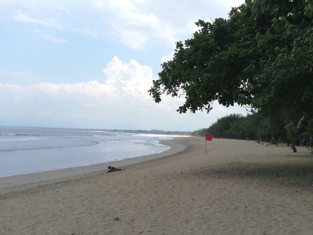seorang turis rela panjat pagar pantai kuta. hanya untuk berjemur di pantai. ( foto : HMP/ide )