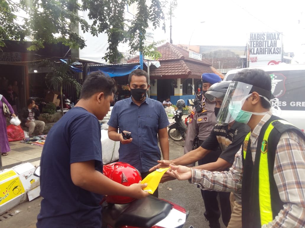 Anggota Polres Gresik ketika membagikan masker gratis kepada masyarakat.