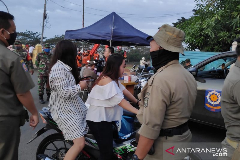 Petugas Satpol PP Jakarta Timur menghentikan pengendara sepeda motor yang berniat mengunjungi bantaran Sungai Banjir Kanal Timur (BKT), Senin (6/7/2020). Pemkot Jaktim kembali memperketat pengawasan BKT menyusul angka penderita COVID-19 yang masih tinggi 