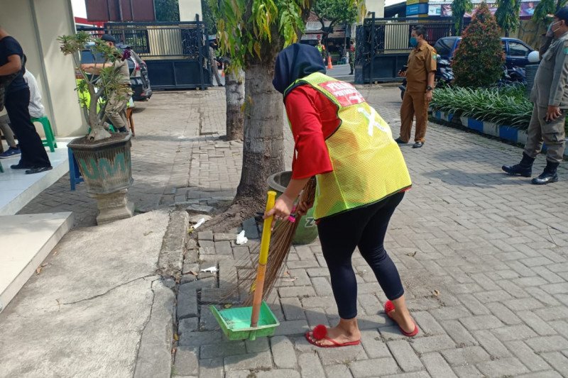 Sejumlah warga yang tidak memakai masker di Krian, Sidoarjo, Jatim dihukum kerja sosial dengan membersihkan halaman kantor Kecamatan Krian, Sidoarjo. (Antarajatim/Polresta Sidoarjo /IS)