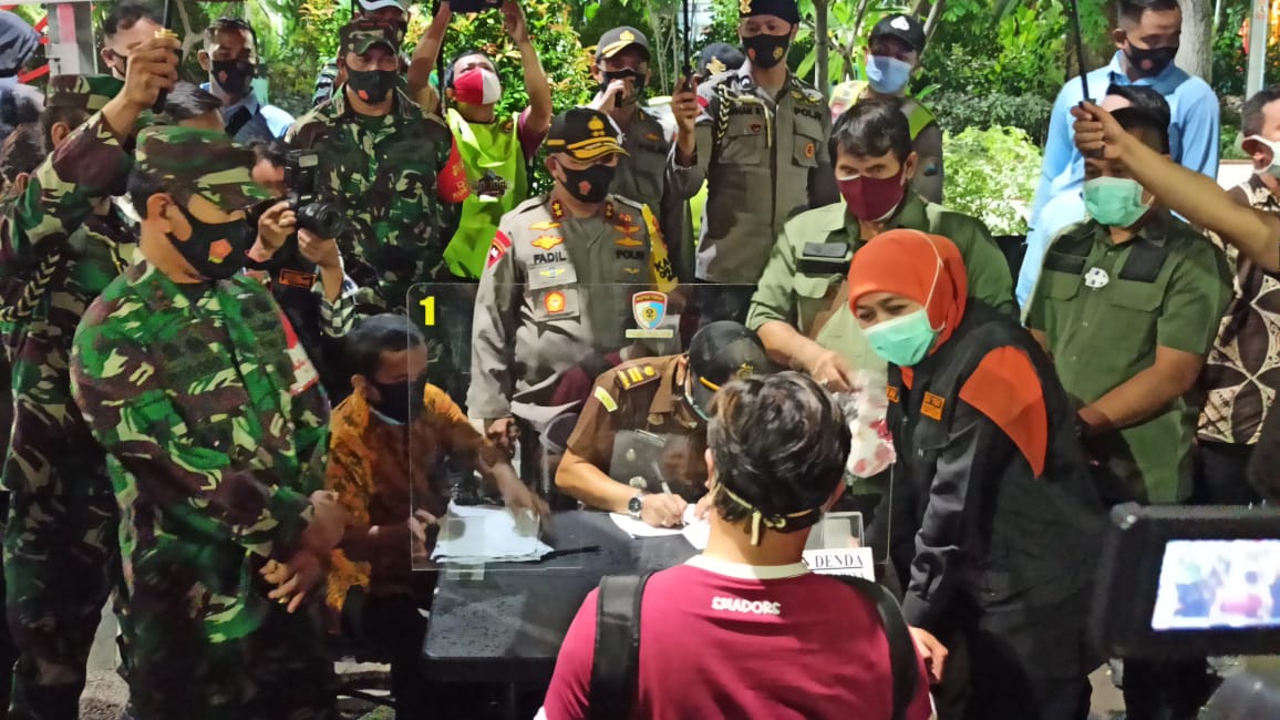 Salah seorang warga yang terjaring razia yustisi protokol kesehatan menjalani sidang di Taman Bungkul, Surabaya.
