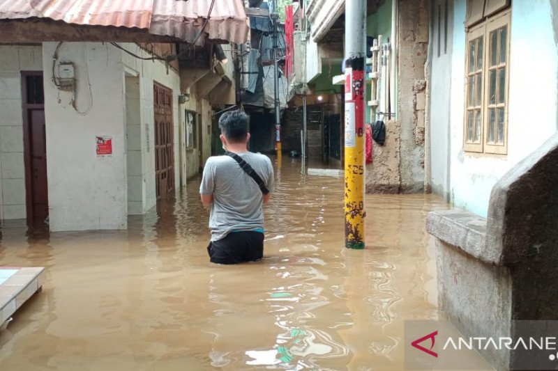 Warga Kebon Pala, Kampung Melayu, Jatinegara, Jakarta Timur, melintas di RT 11/RW 05 yang terendam banjir dengan ketinggian berkisar 50-70 sentimeter, Selasa (22/9/2020) pagi. Banjir di kawasan itu dipicu oleh luapan Kali Ciliwung imbas peningkatan debit 