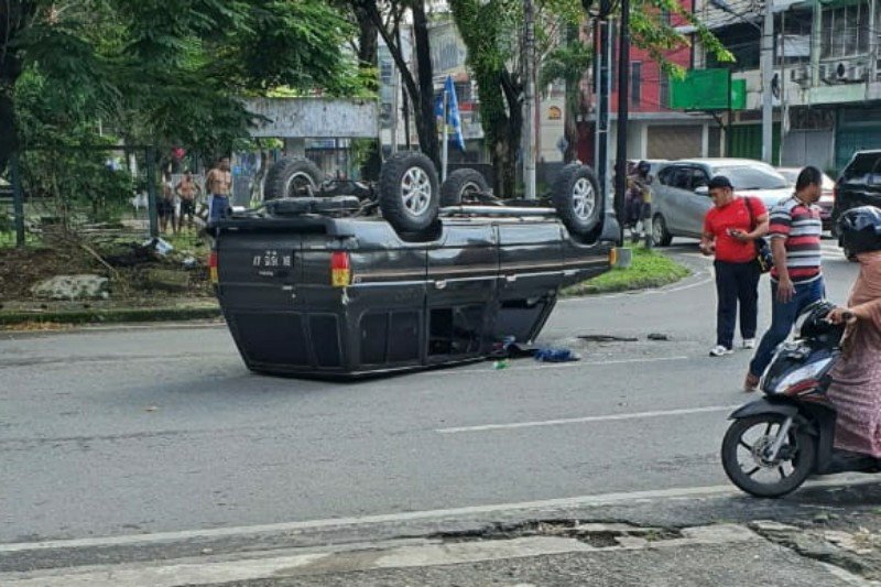 Satu unit mobil Toyota Kijang nomor registrasi BK 1615 AV terguling di persimpangan Jalan Sutomo-Jalan HM Yamin, Medan, Minggu. ANTARA/HO