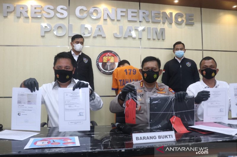 Polisi menunjukkan surat rapid test antigen palsu yang dijual oleh tersangka berinisial IB, saat merilis kasus tersebut di Mapolda Jatim, Surabaya, Senin (11/1/2021). (ANTARA Jatim/Willy Irawan)