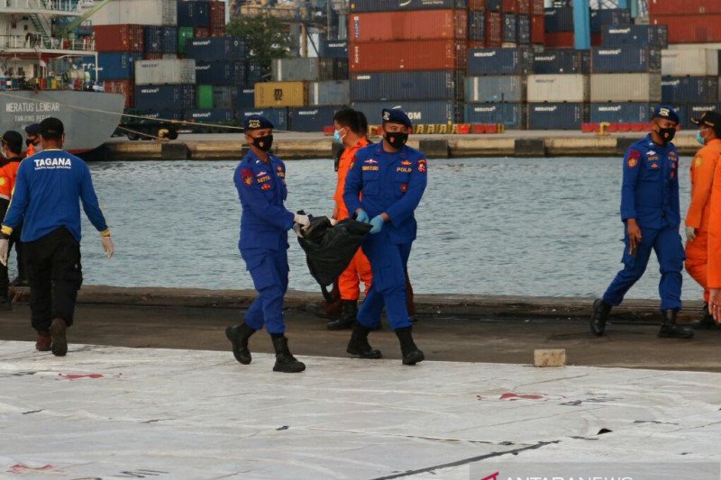 Personel Polairud Baharkam Polri membawa kantong jenazah korban kecelakaan pesawat Sriwijaya Air SJ-182 yang dievakuasi oleh Badan Nasional Pencarian dan Pertolongan (Basarnas), Sabtu (15/01/2021). ANTARA/Fianda Sjofjan Rassat