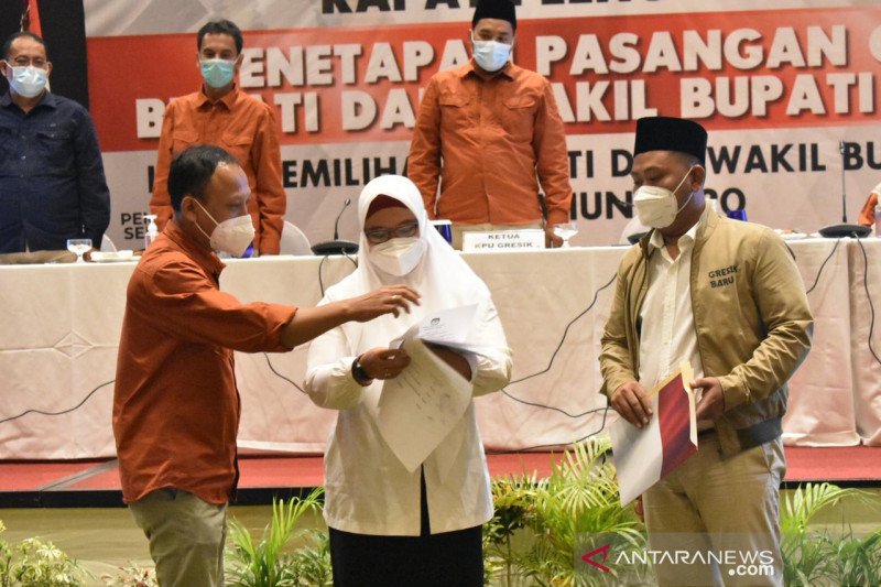 Ketua KPU Gresik, Ahmad Roni (kiri) menyerahkan surat penetapan kepada wakil bupati terpilih Aminatun Habibah (tengah) disaksikan bupati terpilih Akhmad Yani (kanan) dalam acara penetapan Pilkada Gresik di Hotel Aston, Jumat (22/1) (ANTARA Jatim /A Malik 