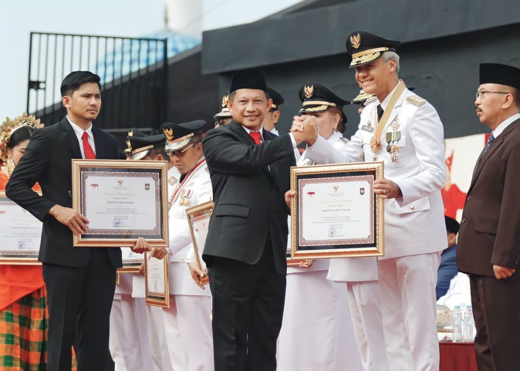 Menteri Dalam Negeri, Tito Karnavian kepada Ganjar Pranowo, di Anjungan City of Makassar Pantai Losari, pada Peringatan Hari Otonomi Daerah (Otda) XXVII, Sabtu (29/4/2023).