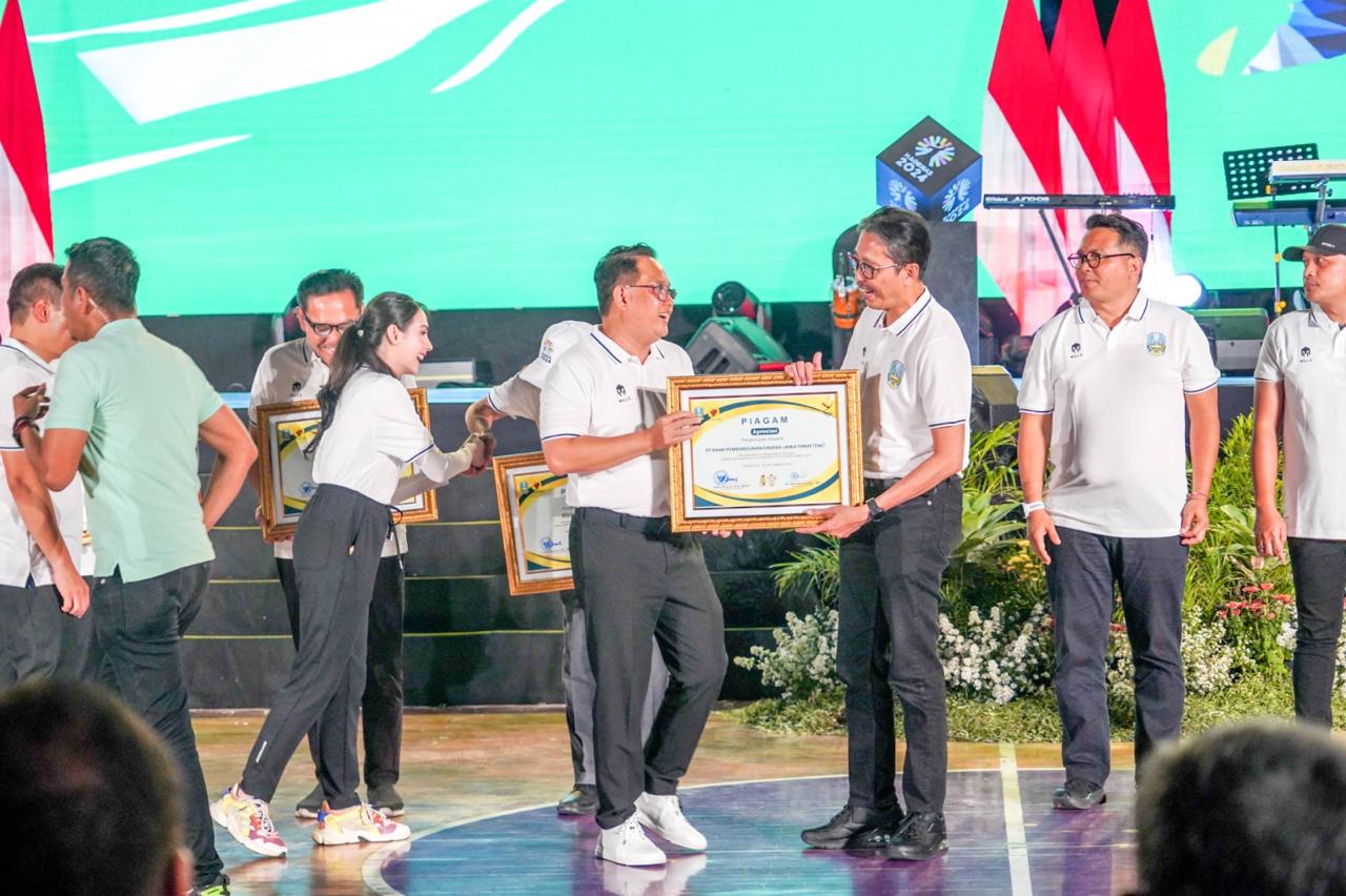 Pj. Gubernur Jawa Timur Adhy Karyono saat menyerahkan penghargaan kepada Direktur Utama bankjatim Busrul Iman dalam upacara puncak peringatan Hari Olahraga Nasional XLI tahun 2024 pada Kamis malam (17/10).