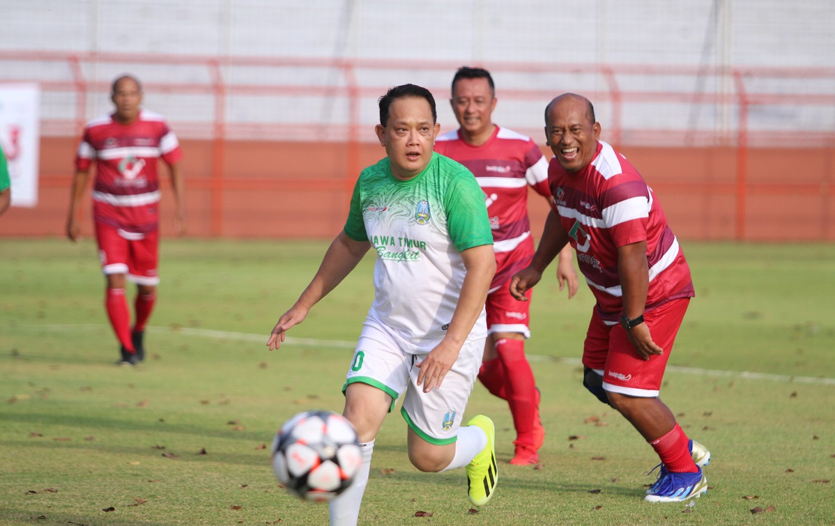 Penjabat (Pj.) Gubernur Jawa Timur Adhy Karyono (kiri) dikawal ketat oleh Johanes Koento Eko Pramono, Pemimpin bank jatim Cabang Utama Surabaya pada pertandingan eksibisi sepak bola