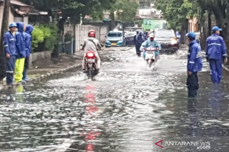 Pengendara melintas di genangan di Jalan Bujana Tirta Raya, Pisangan Timur, Jakarta Timur, Ahad (24/1/2021). (ANTARA/HO-Sudin SDA Jaktim)