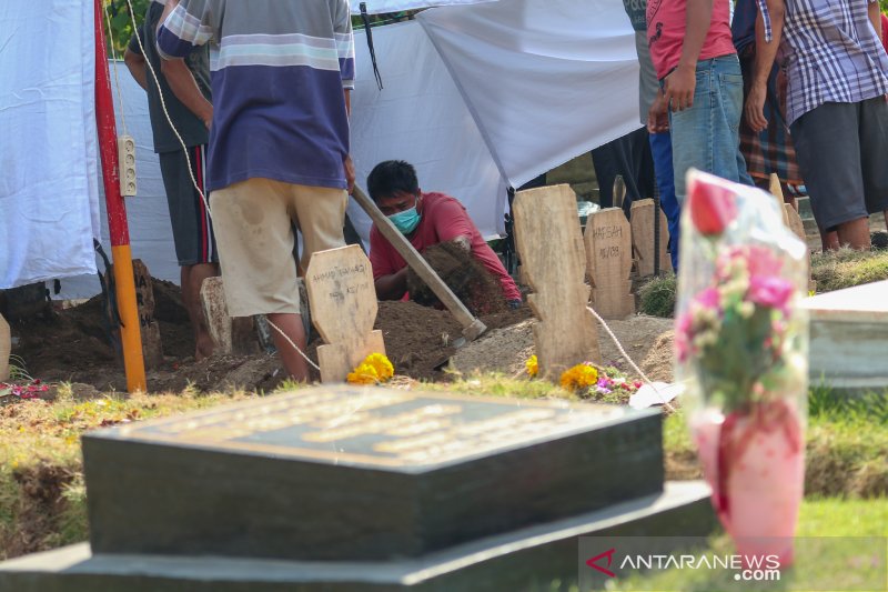 Petugas pemakaman ketika membongkar makam LNS untuk kebutuhan autopsi di TPU Karang Medain, Kota Mataram, NTB, Senin (3/8/2020). (ANTARA/Dhimas B.P.)

