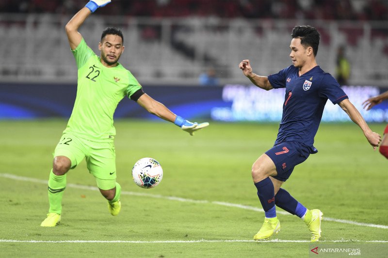 Kiper Timnas Indonesia Andritany Ardhiyasa (kiri) berusaha menghentikan pemain Timnas Thailand Supachok Sarachat pada laga lanjutan Grup G Kualifikasi Piala Dunia 2022 zona Asia di Stadion Utama Gelora Bung Karno, Senayan, Jakarta, Selasa (10/9/2019). Tim
