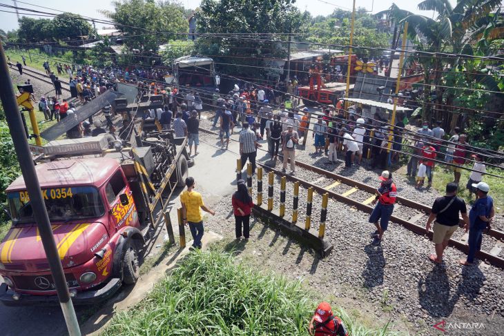 Suasana evakuasi bangkai bus pariwisata PO Harapan Jaya yang tertabrak KA Rapih Doho di perlintasan kereta api tanpa palang pintu di Desa Ketanon, Tulungagung, Jawa Timur, Minggu (27/2/2022).  foto :  Antara Jatim